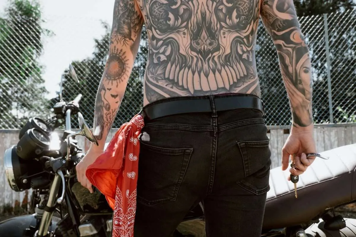Photo by cottonbro studio on Pexels.com. A male biker, shirtless, showing off his full back and arm tattoos.